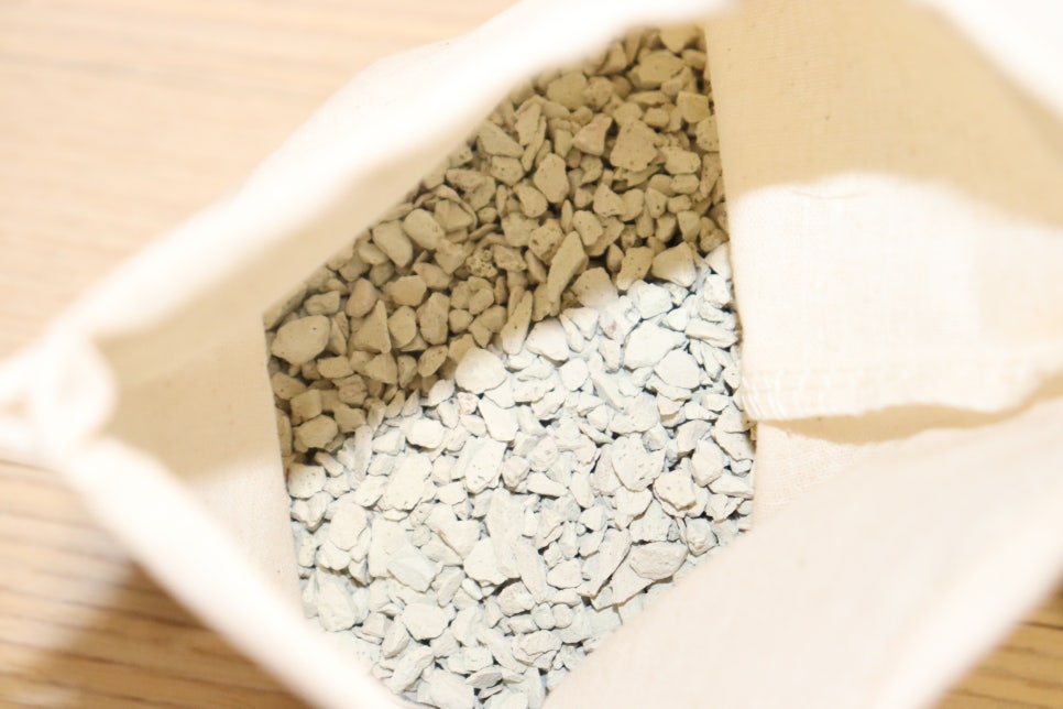 Close-up of a clear glass jar filled with white zeolite beads on a wooden table in a cozy living spa