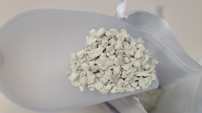 Realistic photo of researchers in a modern lab examining zeolite samples with a digital pore-size vi