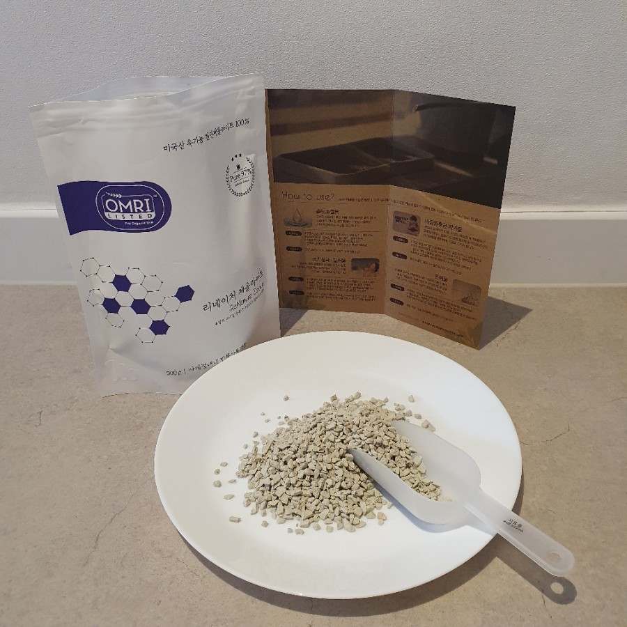 Realistic photo of a laboratory bench with a 10L water container, glass beakers, zeolite pellets, an