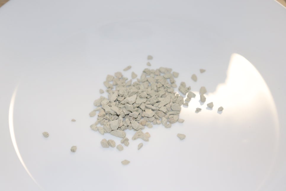 Realistic close-up photo of field soil showing visible zeolite crystals among the soil particles und