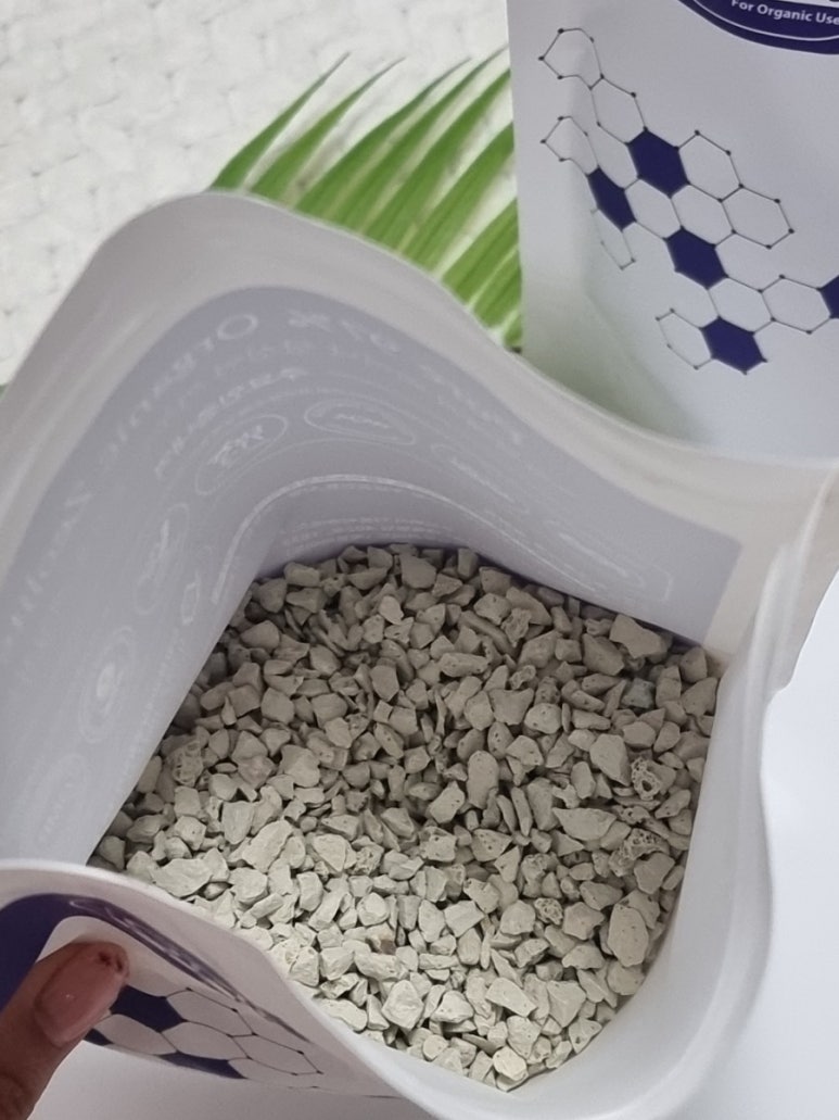 Realistic photo of large-scale zeolite bags and fertilizer bags beside a field, illustrating bulk pu