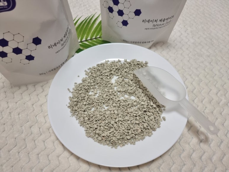 Two glass bowls on a clean lab bench holding zeolite pellets and activated carbon, a small balance s