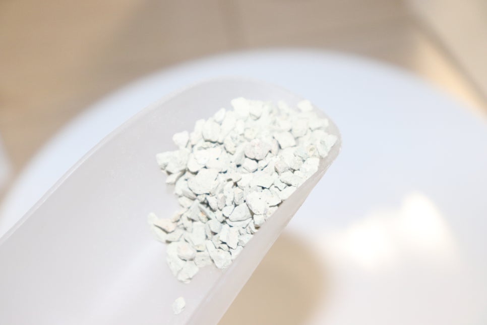 Scientist examining adsorption performance on a tablet while small samples of zeolite and activated 