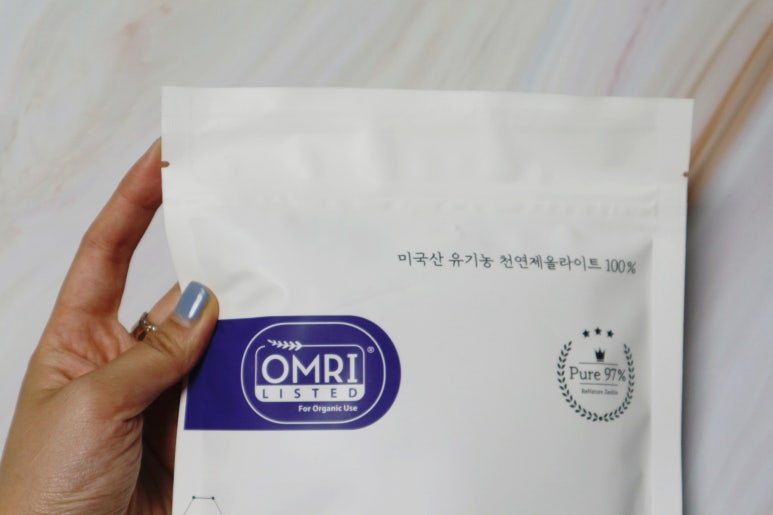 Indoor farm office scene showing a hand using a calculator beside a bag of soil amendment and notebo