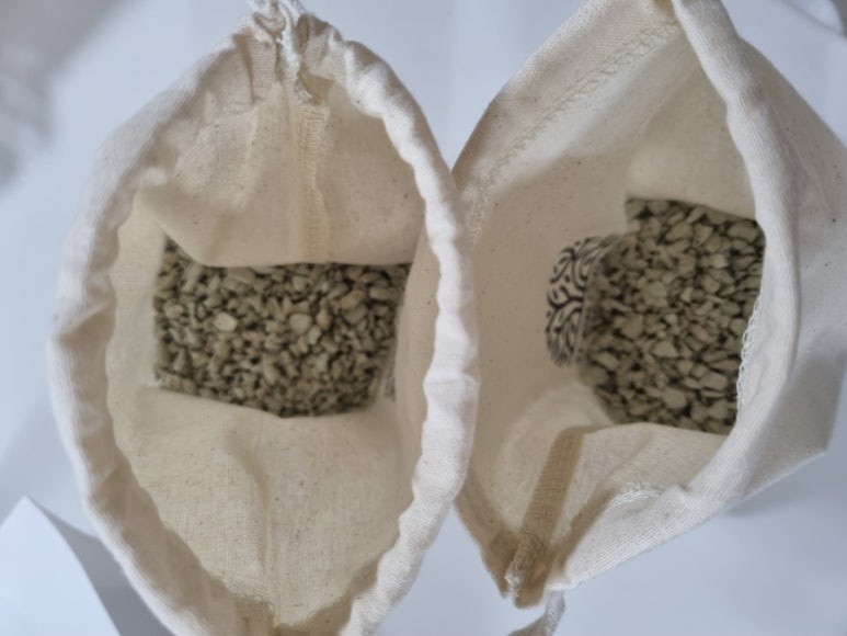 Two unlabeled bags of granular material on a clean kitchen counter, natural light, conveys cost cons