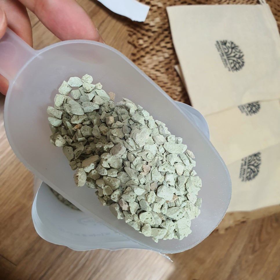 Three transparent containers on a wooden table holding different eco-friendly filter media with vari
