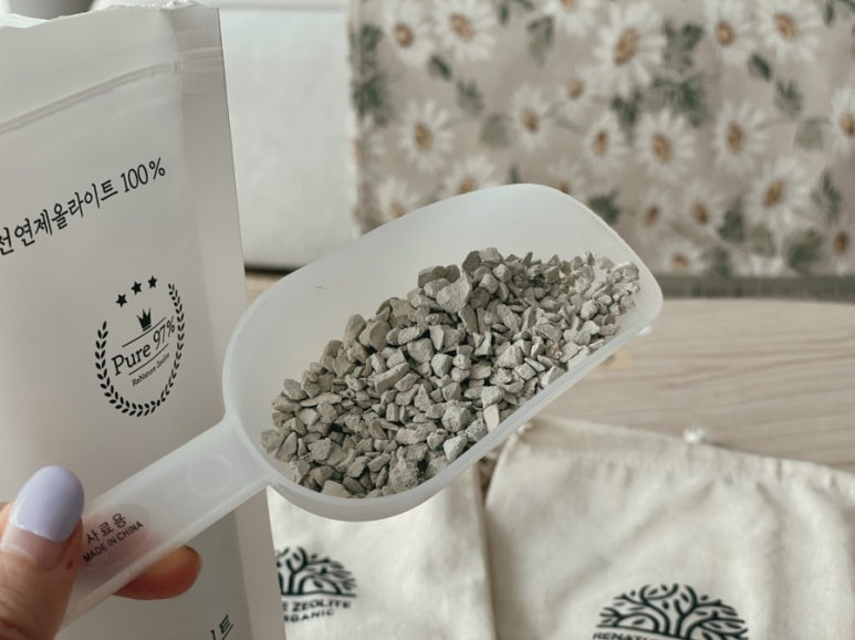 Kitchen counter scene with a calculator and a pile of zeolite sachets to imply cost efficiency, clea