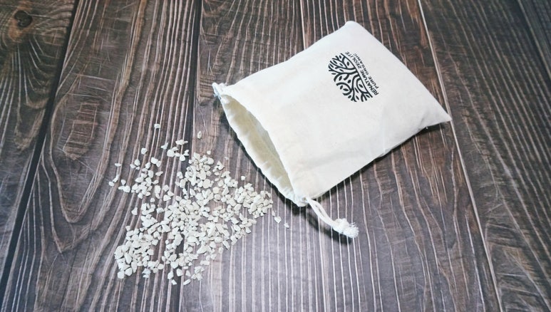 Close-up of natural deodorant ingredients arranged on a wooden surface: baking soda, lemon slices, e