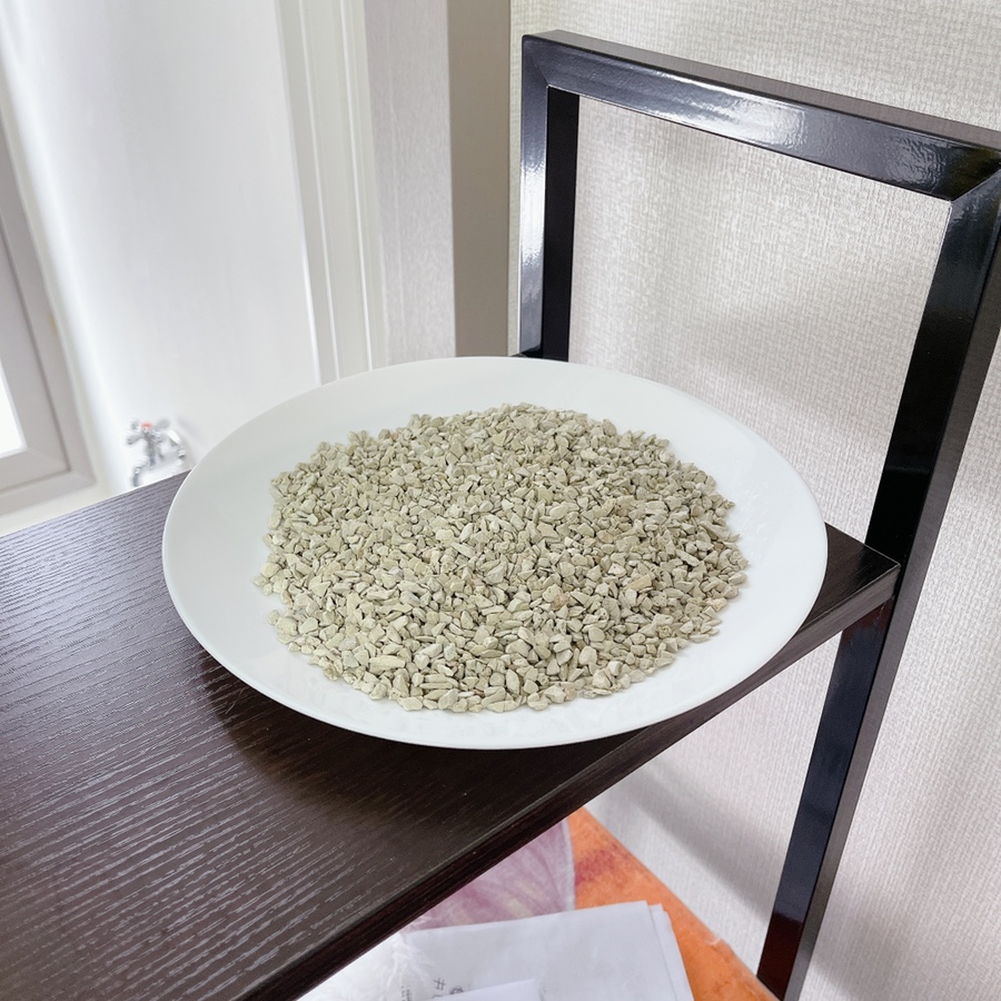 Sunlit balcony or windowsill showing a shallow tray of zeolite being dried/regenerated in the sun, s