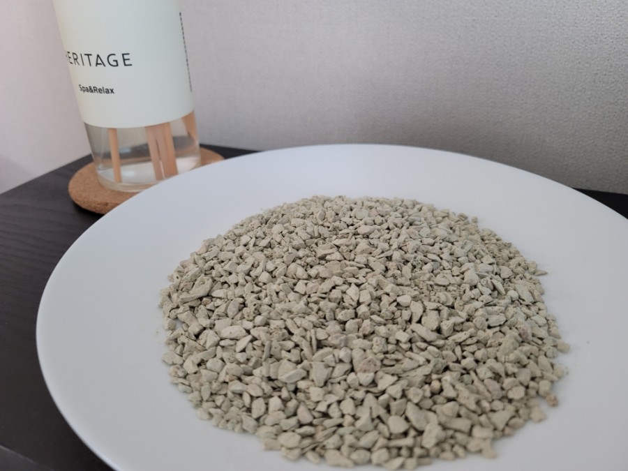 Realistic photo of zeolite pellets next to a small heater and timer, suggesting a regeneration step 