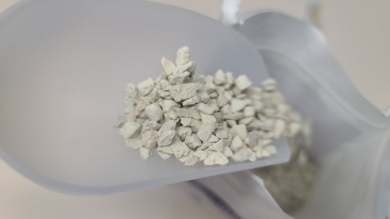 Researchers in a clean lab testing a customized zeolite sample for CO2 separation in a small-scale r