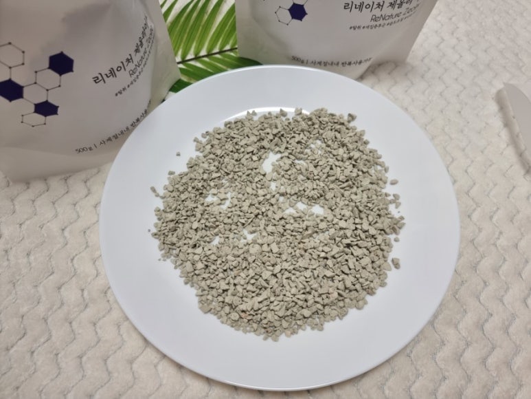 Two filter cartridges in a home filtration unit on a kitchen counter, one with zeolite beads resembl