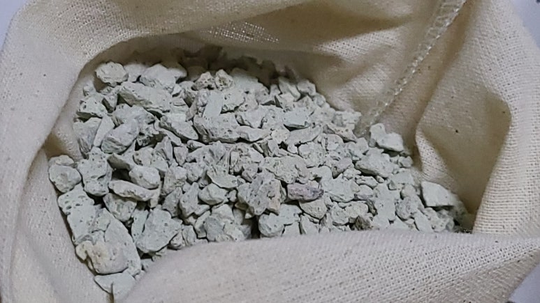 Farmer and agronomist in a field examining soil samples with bags and a notebook, natural light and