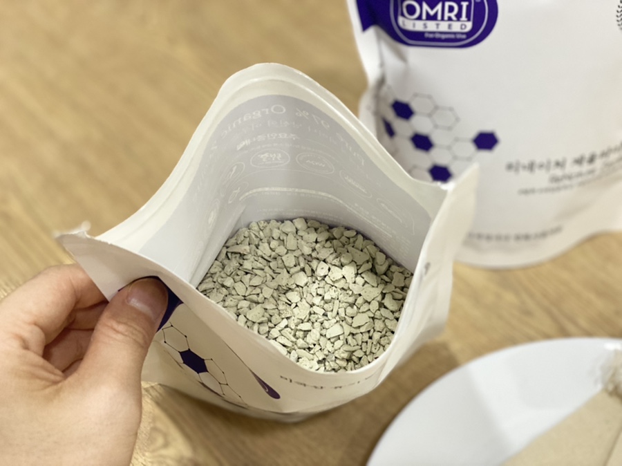 Maintenance scene of replacing media in a filter, hand placing new pellets into the chamber while th