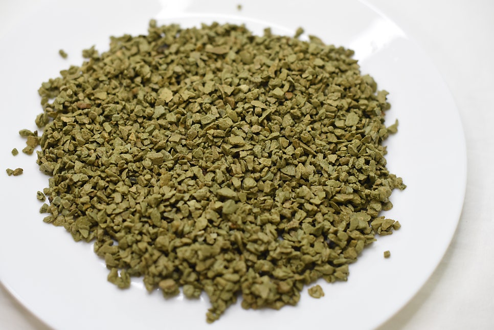 Vibrant green crops in a field after soil amendment, with irrigation lines and a clear blue sky, ill