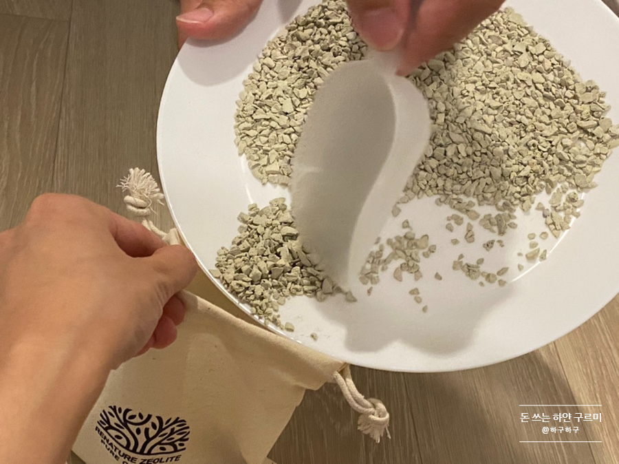 Hands placing zeolite pellets into a reusable container on a kitchen counter, natural light, simple 