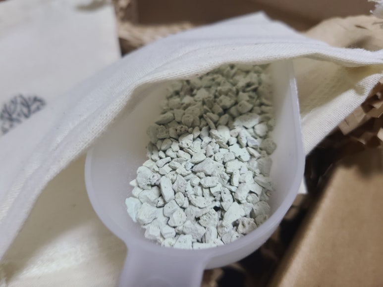 Laundry area where clothes are pre-treated with deodorant spray and a washing machine sits in the ba