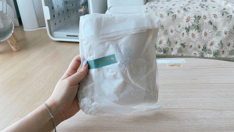 Healthcare or regulatory context: clean lab-like scene with a person examining a product package; ba