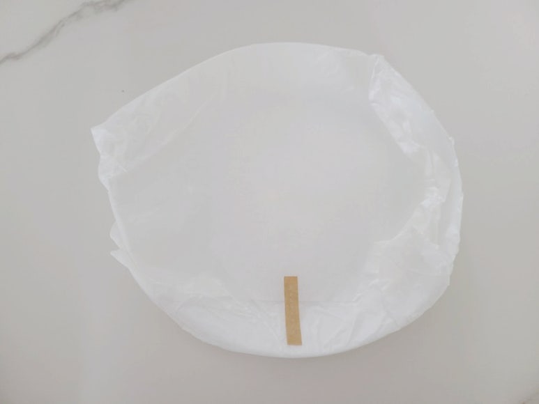 Engineer inspecting a used filter cartridge and documenting maintenance steps in a clean workshop, s