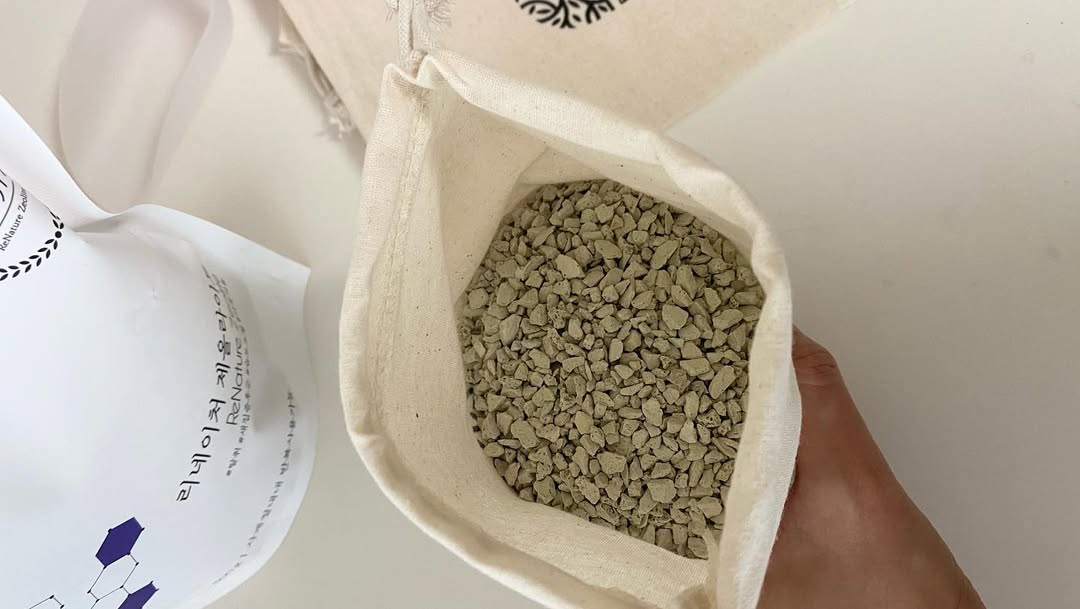 Maintenance scene showing a technician inspecting a filter column packed with zeolite beads, indicat