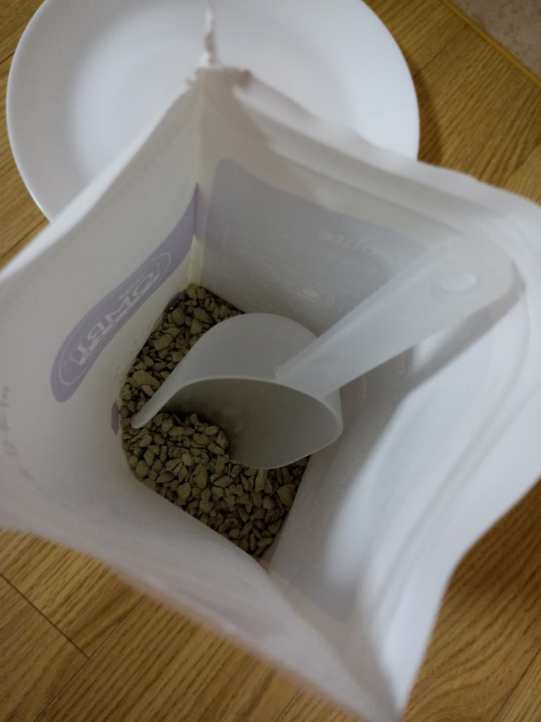 Kitchen scene with a pet food bag, a smart feeder, and a monitor showing safety checks, illustrating